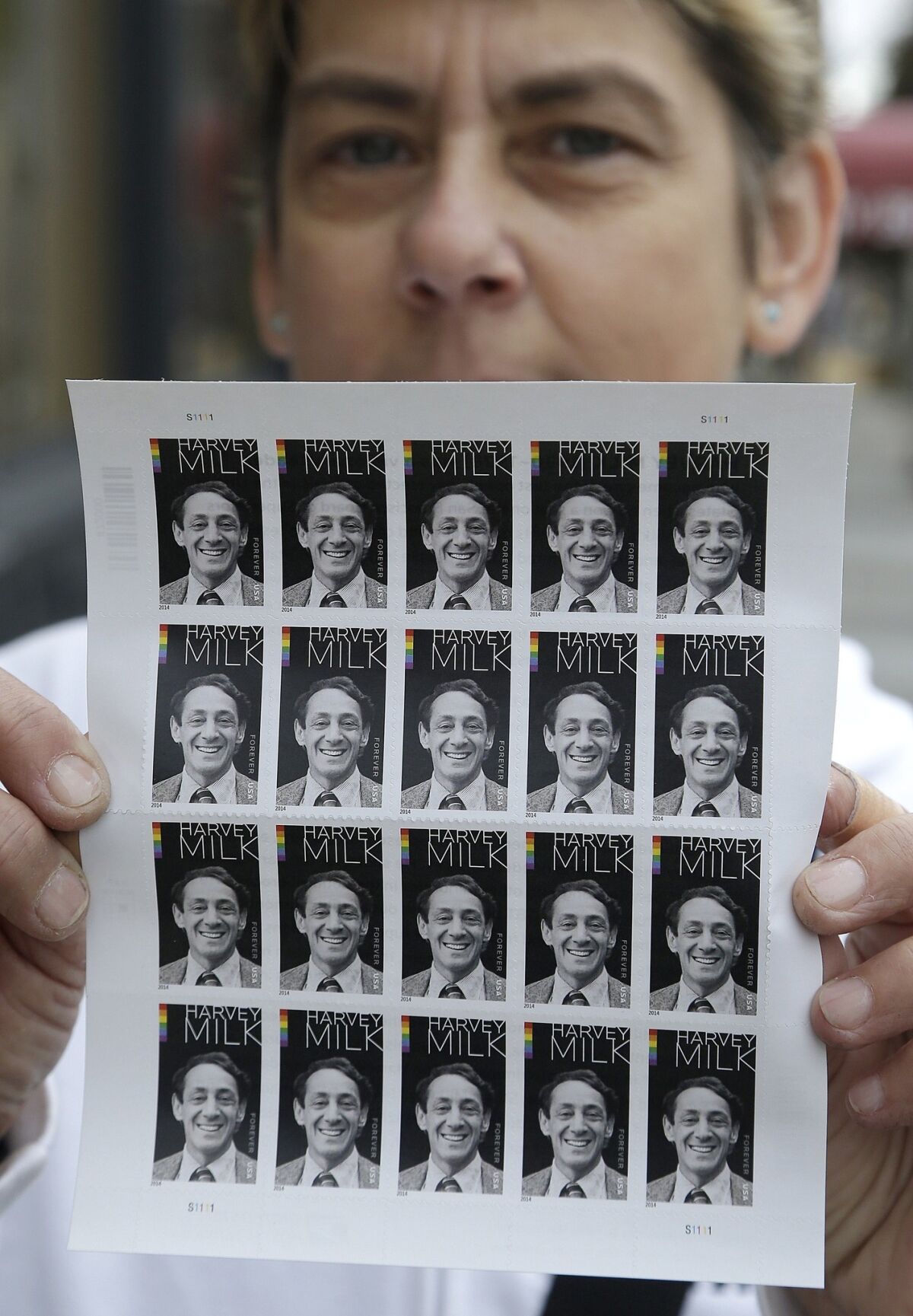 Robert Moore holds a sheet of Harvey Milk commemorative stamps, released Thursday, at a U.S. Postal Service branch in San Francisco.