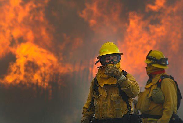 Afternoon winds whip up flames on Lake Elizabeth Road near Highland Street as firefighters work to get an upper hand on the Crown fire. See full story