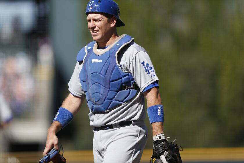 Dodgers catcher A.J. Ellis walks back to home plate during a game against the Rockies.