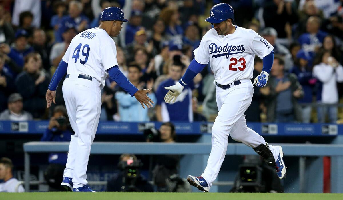 Dodgers' Adrian Gonzalez is greeted by third base coach Lorenzo Bundy after hitting his third home run of the game against the San Diego Padres at Dodger Stadium on Wednesday.