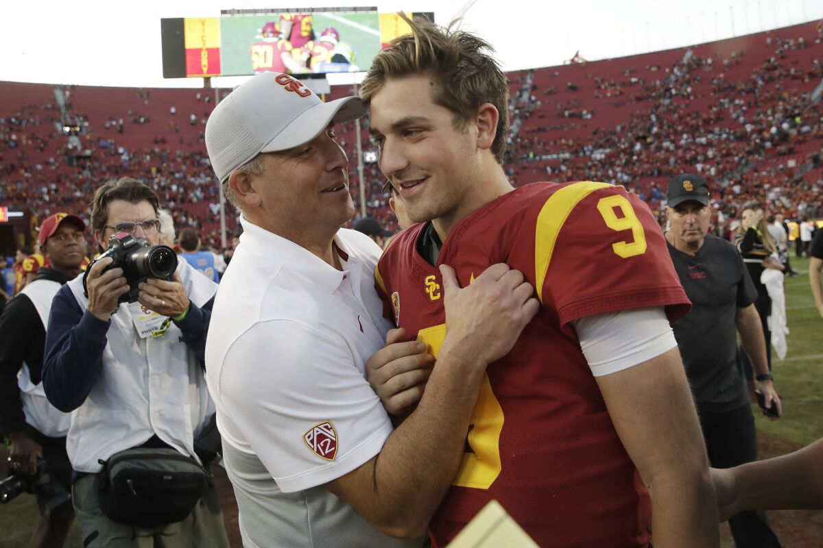 FILE - In this Nov. 23, 2019 file photo, Southern California head coach Clay Helton, left, smiles at quarterback Kedon Slovis (9) after a 52-35 win over UCLA in an NCAA college football game in Los Angeles. BOth Helton and now-sophomore Slovis will return in November. (AP Photo/Marcio Jose Sanchez, File)