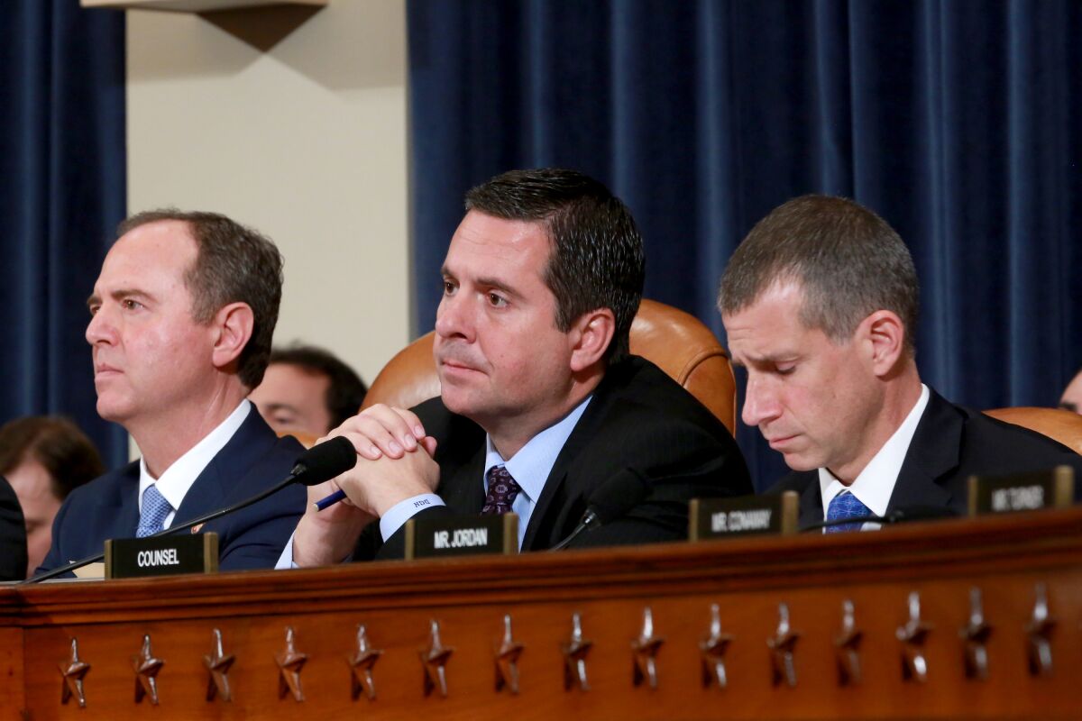 Rep. Adam Schiff, left, Rep. Devin Nunes and Republican counsel Steve Castor list to testimony during an open hearing of the House Intelligence Committee in the impeachment inquiry of President Trump.