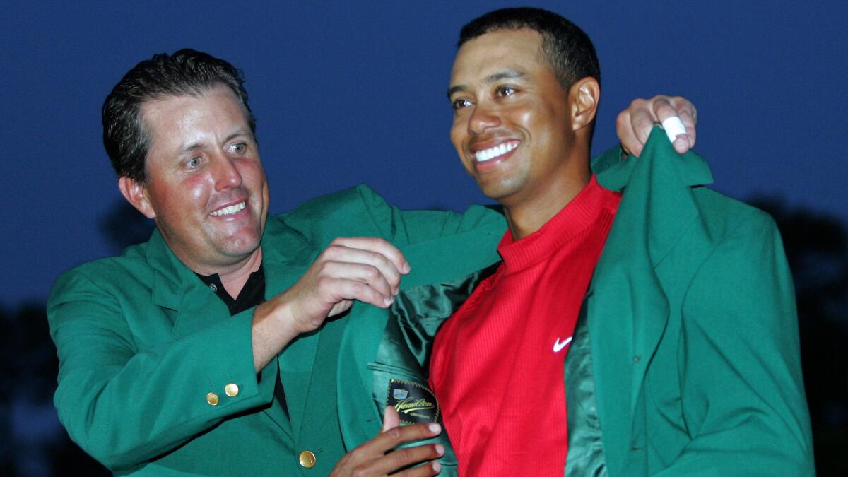 Tiger Woods receives the green jacket from Phil Mickelson after winning the 2005 Masters.