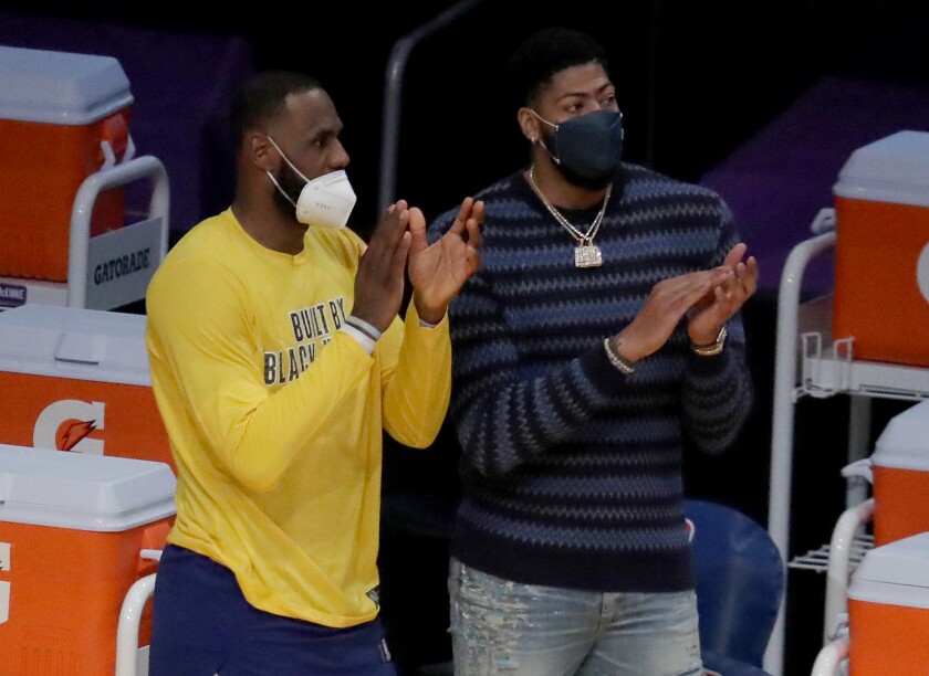 LeBron James and Anthony Davis cheer for the Lakers at the end of the game against the Nets.