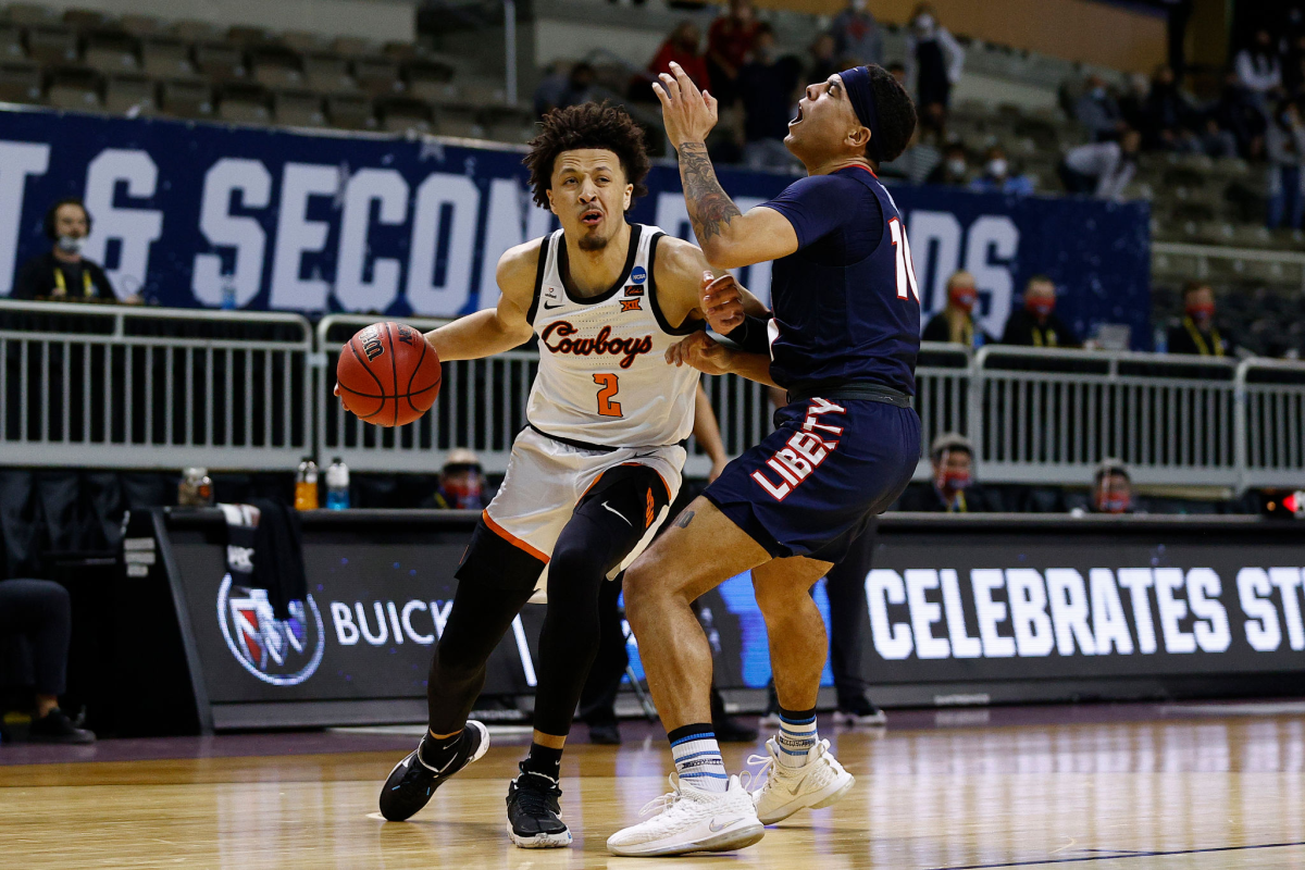 Oklahoma State's Cade Cunningham, left, drives past Liberty's Elijah Cuffee.