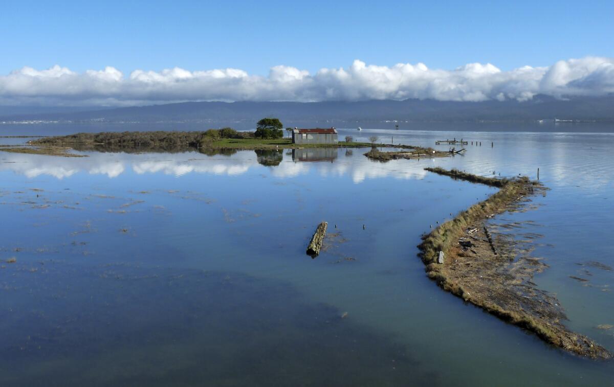 A land mass with a building on it surrounded by water