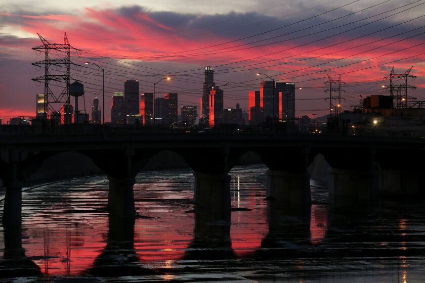 The Los Angeles River reflects late afternoon light as it flows beneath the Soto Street Bridge in Boyle Heights.