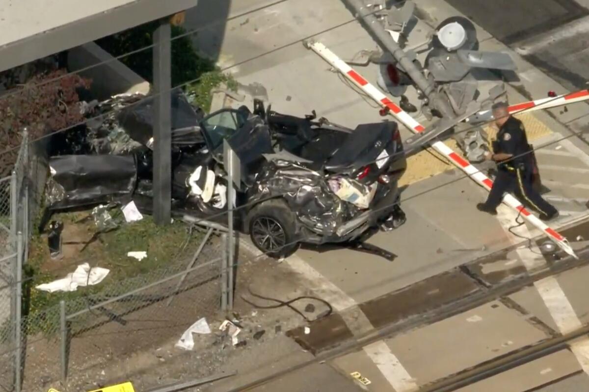 A uniformed police officer walks toward a wrecked car