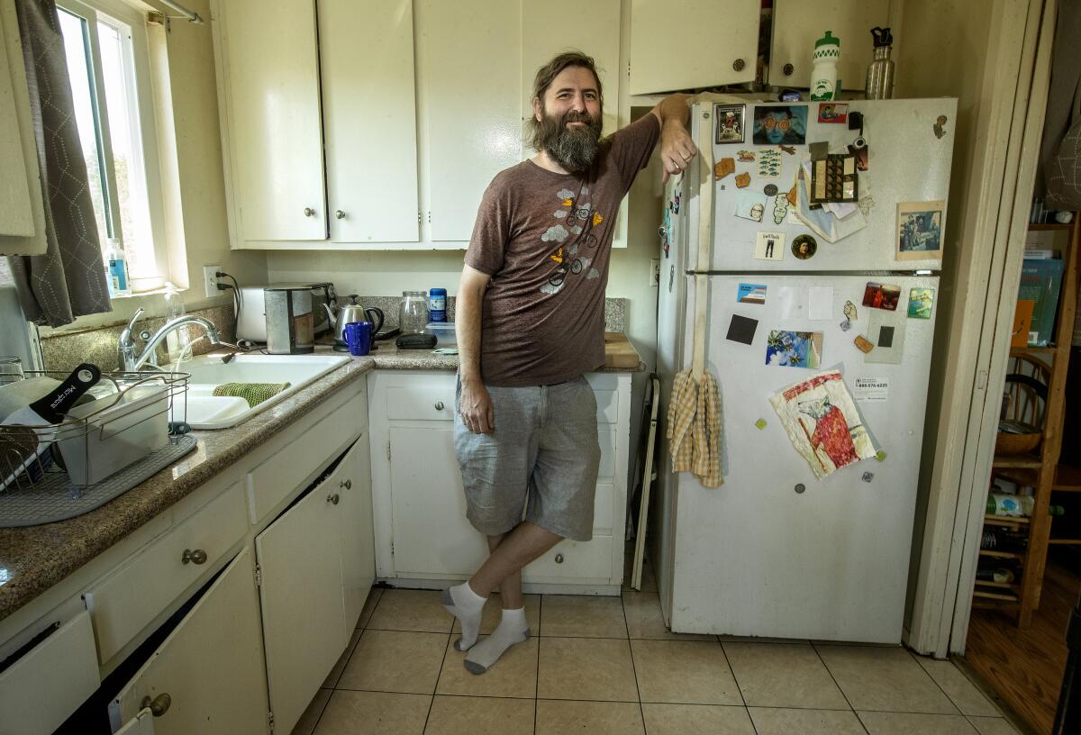  Josh Steichmann stands next to his refrigerator 