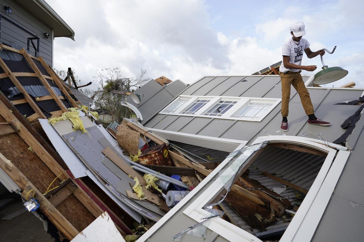 Jeremy Hodges stands on a destroyed storage unit in the aftermath of Hurricane Ida