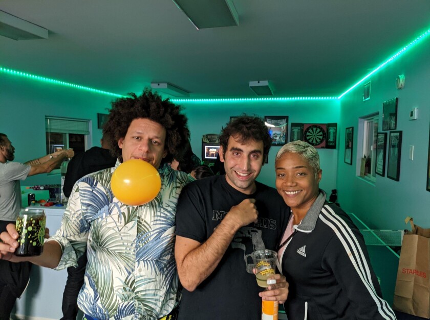 Three people posing for photo in a backstage green room