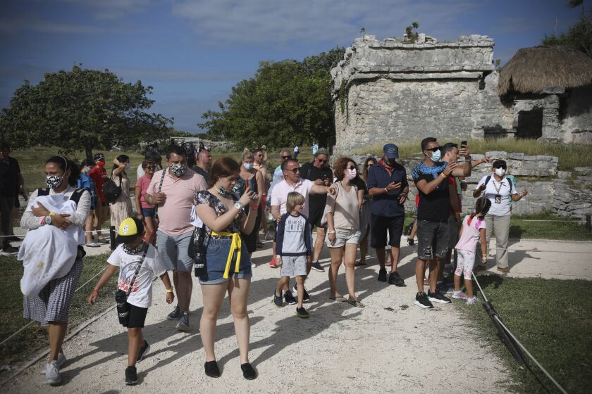FILE - This Jan. 5, 2021 file photo shows tourists, some wearing masks and others not, at the Mayan ruins of Tulum in Quintana Roo state, Mexico, amid the COVID-19 pandemic, with some wearing masks while others are not. Authorities in Mexico's Yucatan peninsula complained Friday, March 26, 2021, about tourists not wearing face masks, as Mexico braces for a surge of Easter Week visitors. (AP Photo/Emilio Espejel, File)