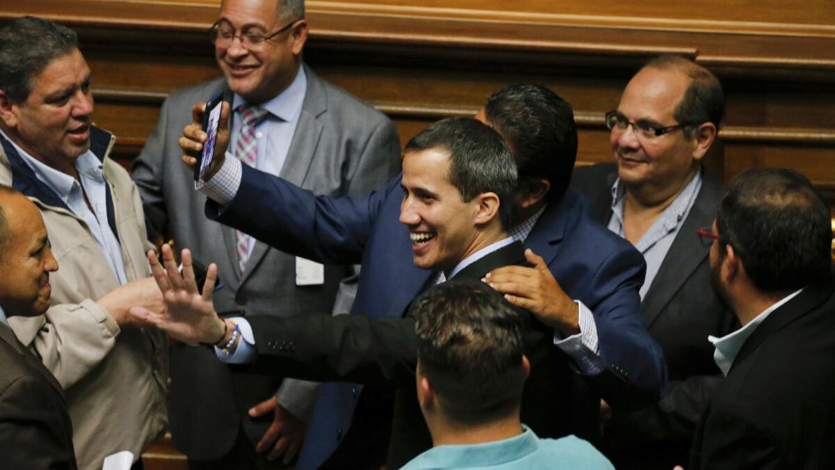 Self-declared acting President Juan Guaido, center, arrives at the National Assembly in Caracas on Tuesday.
