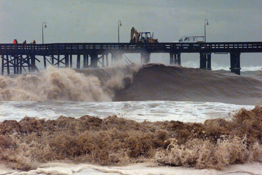 FILE - In this Feb. 2, 1998 file photo, work crews attempt to repair a damaged pier caused by waves that reached 15 feet from the massive El Nino-driven storm in Ventura, Calif. Evidence is mounting that the El Nino ocean-warming phenomenon in the Pacific will spawn a rainy winter in California, potentially easing the state's punishing drought but also bringing the risk of chaotic storms like those that battered the region in the late 1990s. (AP Photo/Nick Ut,File)