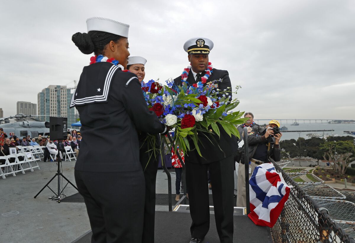 Cmdr. Bralyn Cathey, right, the commanding officer of the guided-missile destroyer USS John Finn