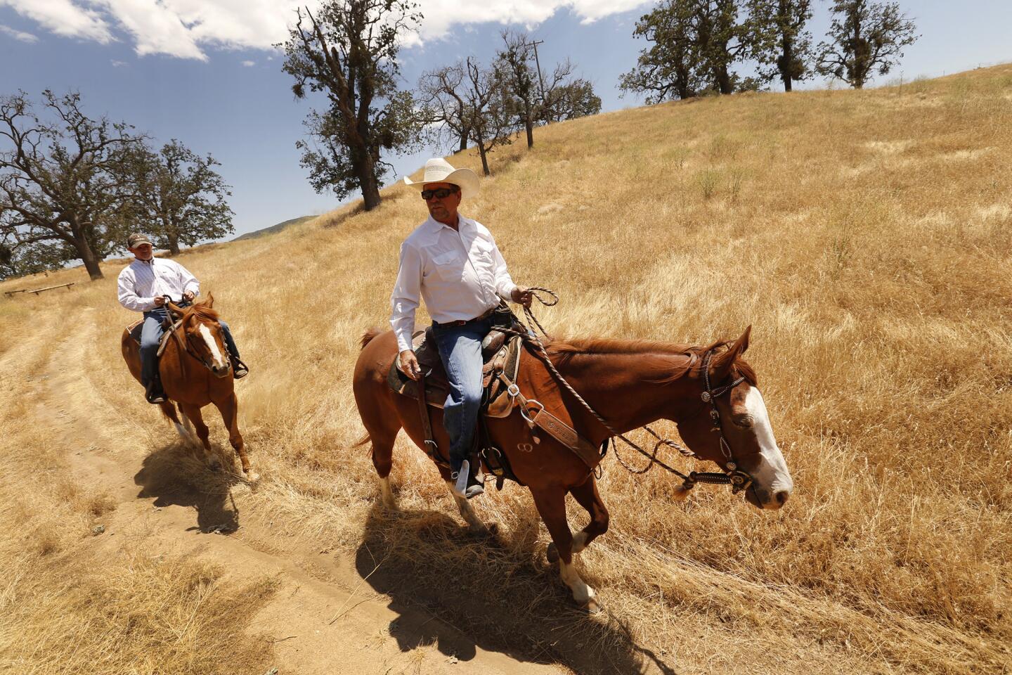 Mike Campeau, director of hunting and equestrian operations, left, and horse trainer Dean Voigt ride through the oak-studded landscape of the Explorer Recreation Area on Tejon Ranch.