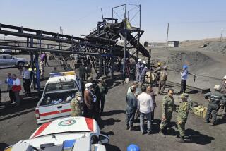 In this photo released by Iranian Red Crescent Society, rescue personnel, police officers and some other people gather around the site of a coal mine where methane leak sparked an explosion on Saturday, in Tabas, some 335 miles (540 kilometers) southeast of the capital Tehran, Iran, Sunday, Sept. 22, 2024. (Iranian Red Crescent Society, via AP)