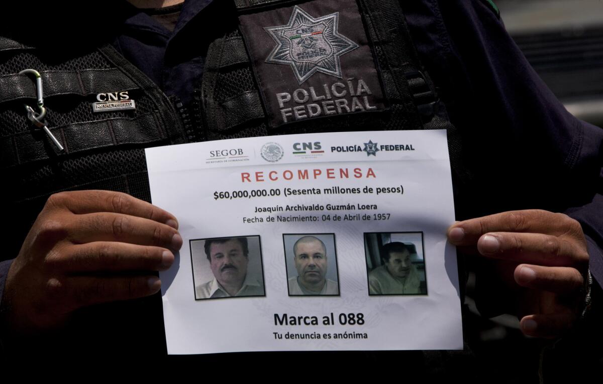 En esta imagen de archivo, el 16 de julio de 2015, un policía federal muestra un aviso de recompensa por información que lleve a la captura del narcotraficante Joaquín "El Chapo" Guzmán, fugado de la prisión de máxima seguridad de Altiplano a través de un túnel subterráneo en Almoloya, oeste de México.