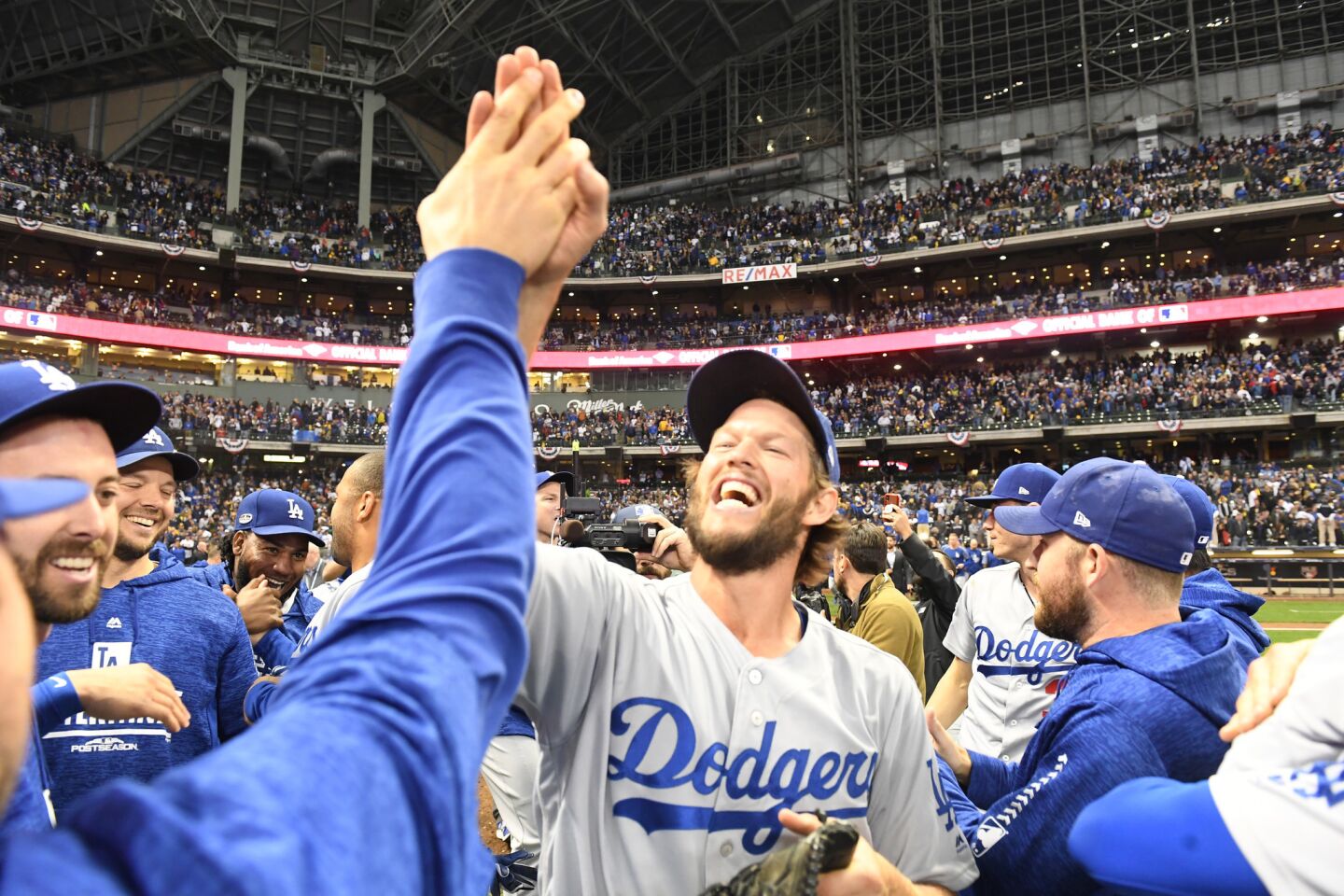 Dodgers Clayton Kershaw celebrate with teammates after defeating the Brewers 5-1 in game 7 at Miller Park.