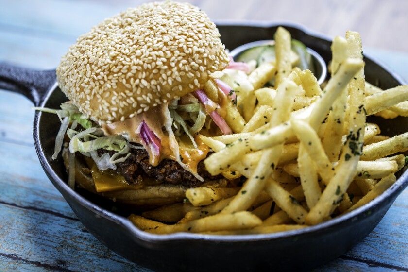 Punch Bowl Social's Knockoff Burger is made with two grass-fed hormone-free beef patties and served with savory rosemary fries.