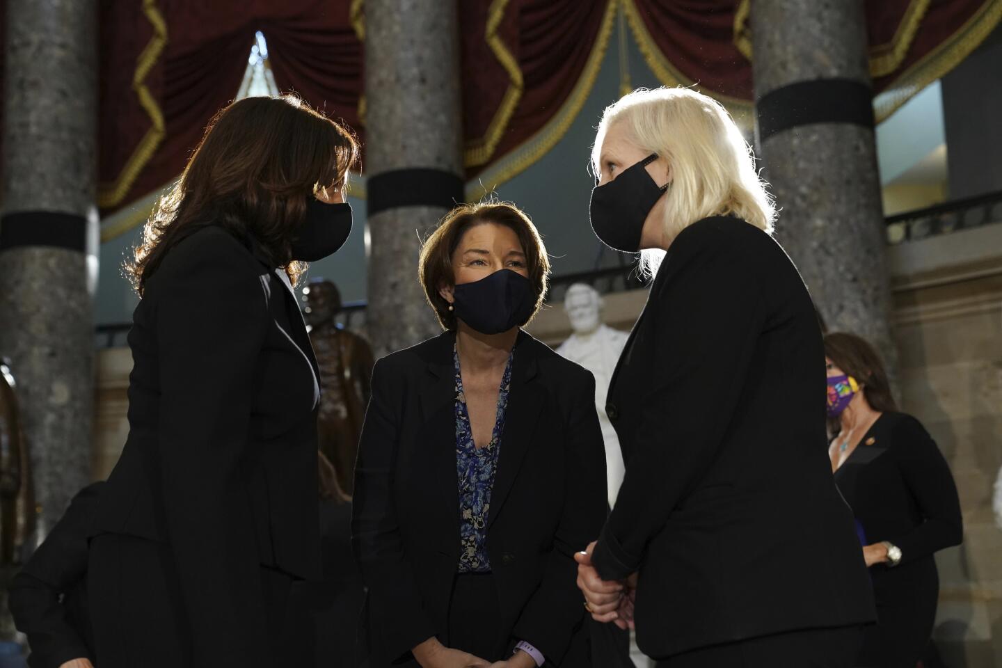Sens. Kamala Harris, left, Amy Klobuchar and Kirsten Gillibrand talk before ceremony for late Justice Ruth Bader Ginsburg
