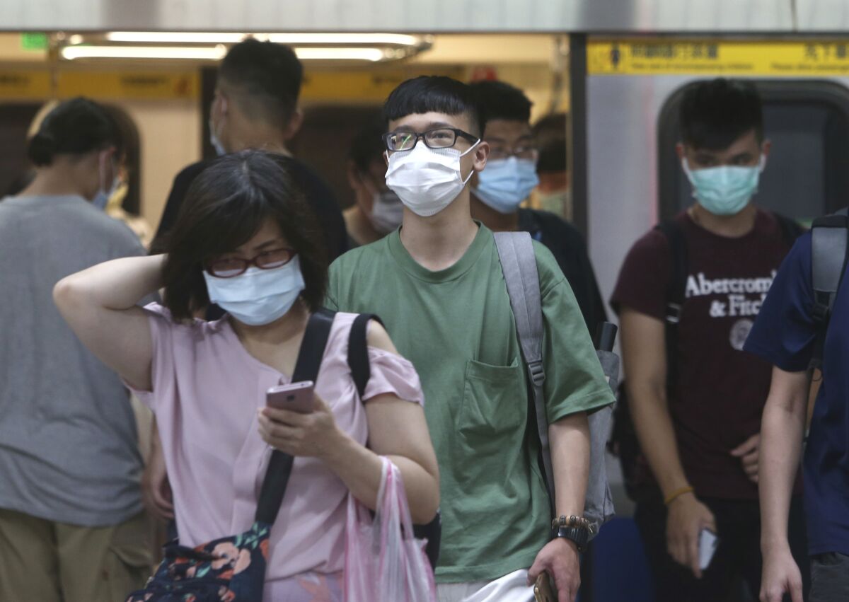 People wear masks on the subway in Taipei, Taiwan.