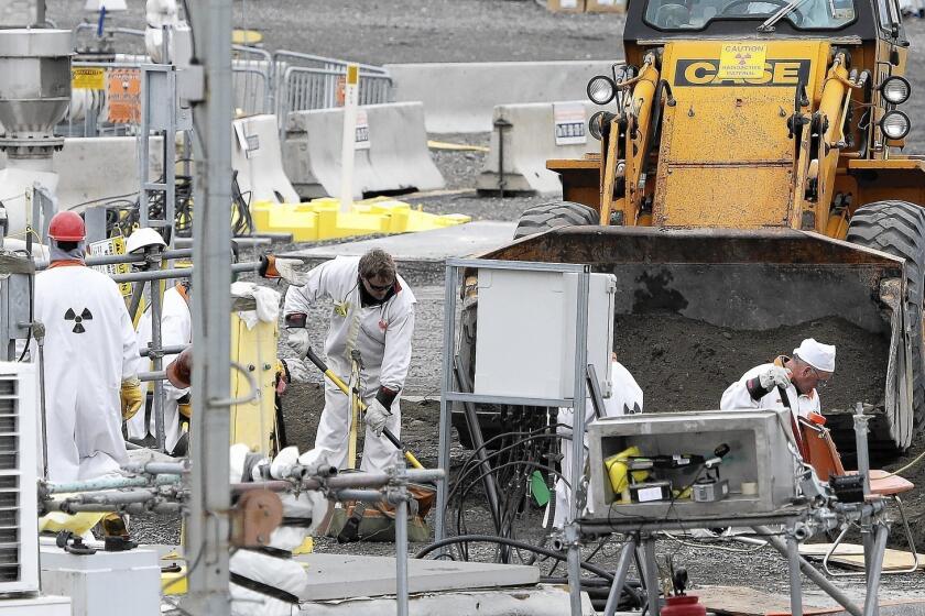 Washington state wants eight new double-shelled storage tanks to be built to hold radioactive waste that is in leaky underground tanks with single steel walls at the former Hanford nuclear weapons site. Above, workers at a tank farm at the sprawling complex.