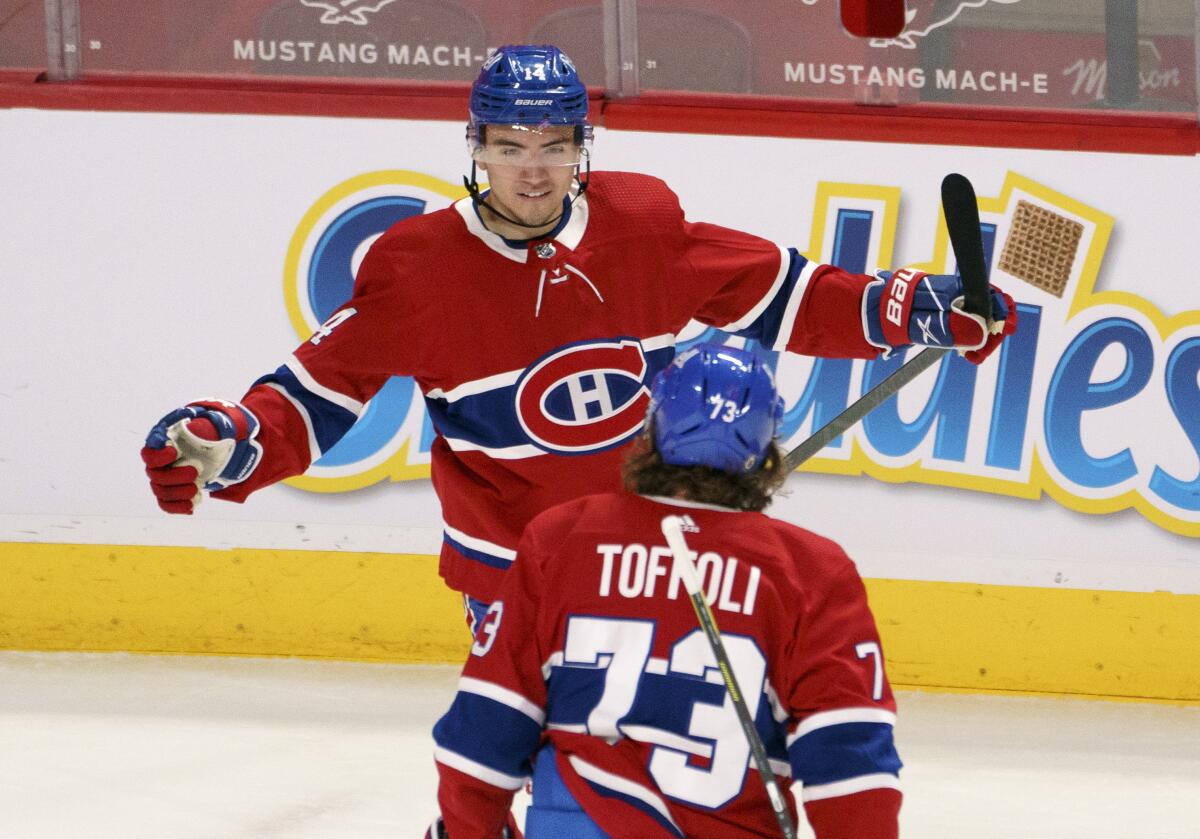 Montreal Canadiens' Nick Suzuki celebrates his goal against the Toronto Maple Leafs with teammate Tyler Toffoli during the first period of an NHL hockey game in Montreal on Monday, April 12, 2021. (Paul Chiasson/The Canadian Press via AP)