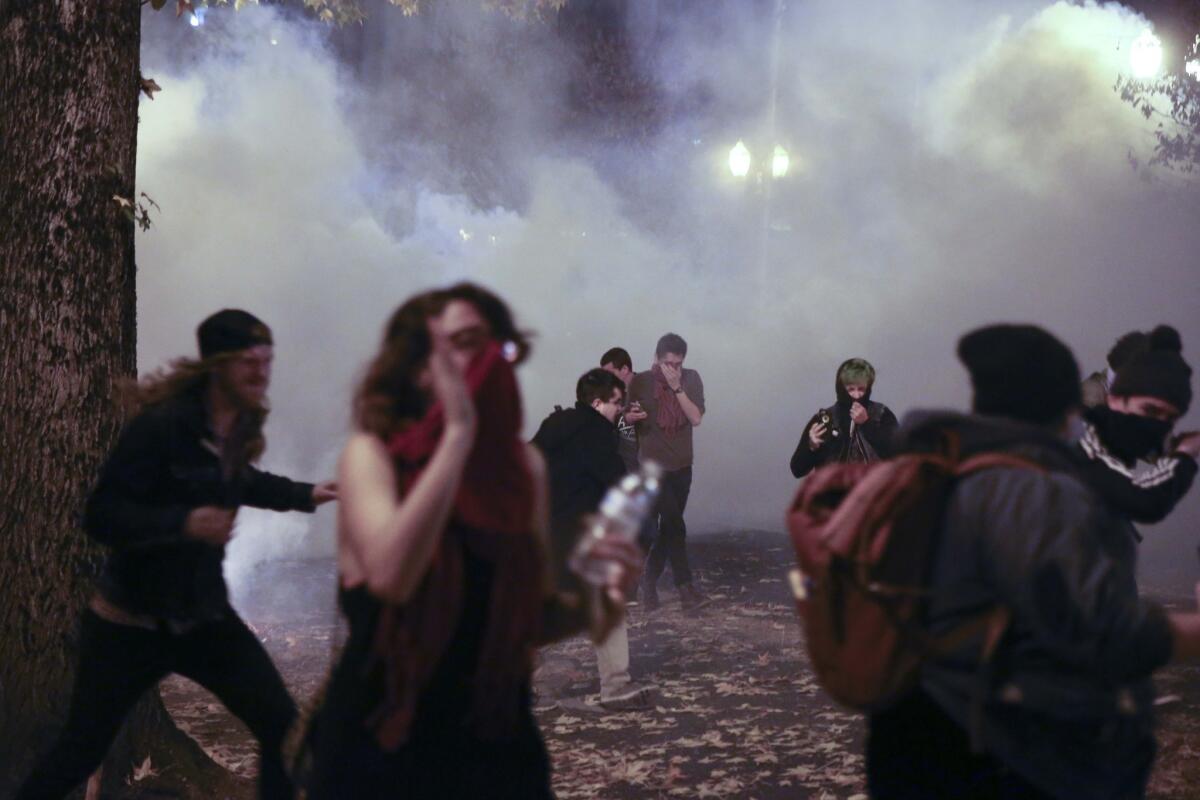 Police in downtown Portland, Ore., attempt to disperse people protesting the election of President-elect Donald Trump on Friday.