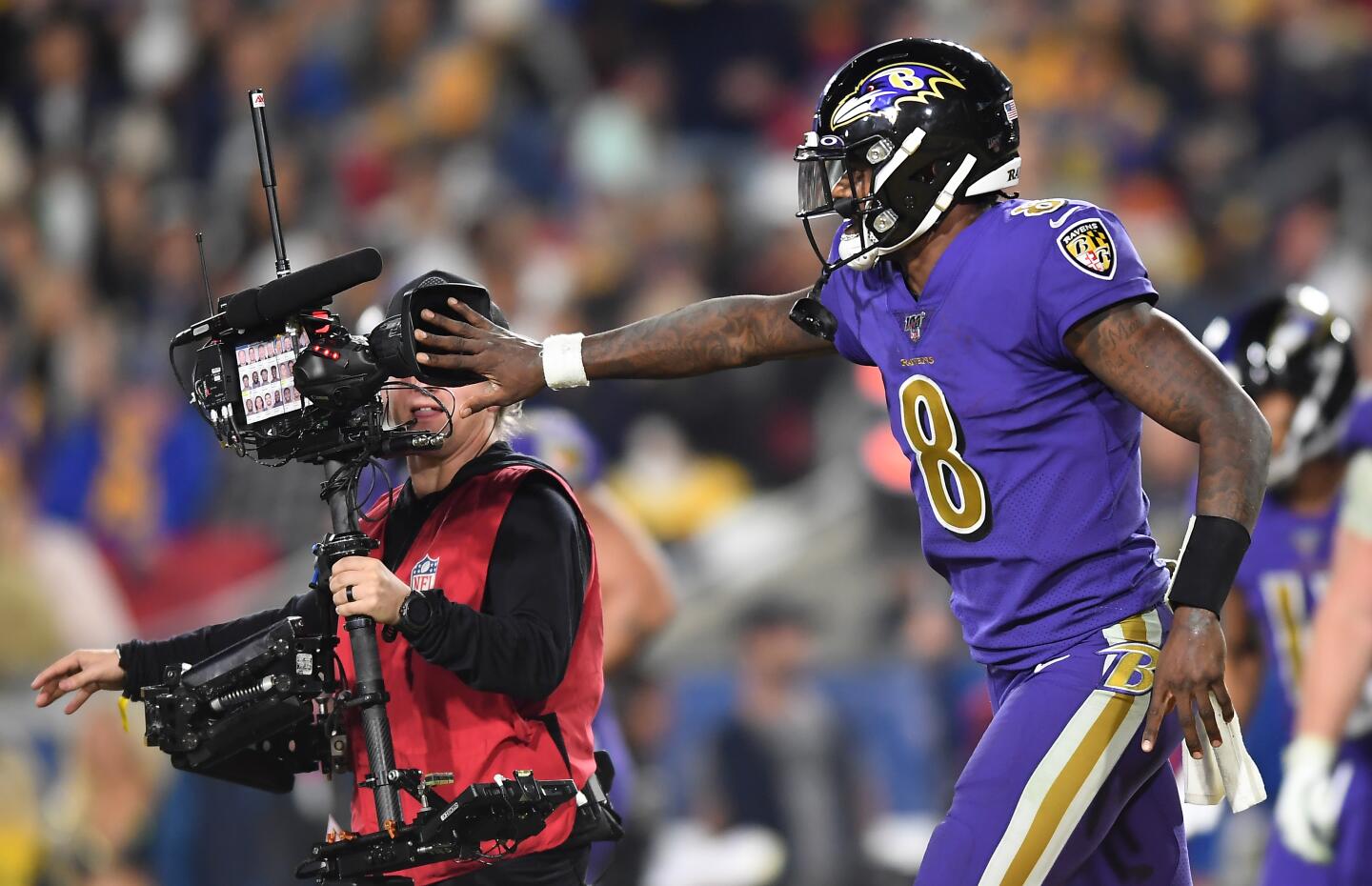 LOS ANGELES, CALIFORNIA NOVEMBER 25, 2019-Ravens quarterback Lamar Jackson covers the lens form a televison cameraman after his team scored a touchdown against the Rams in the 4th quarter at the Coliseum Sunday. (Wally Skalij/Los Angerles Times)