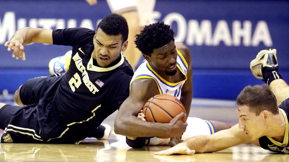 UCLA guard Isaac Hamilton, center, tries to collect a loose ball between Wake Forest's Devin Thomas (2) and Trent VanHorn in the first half Wednesday night.