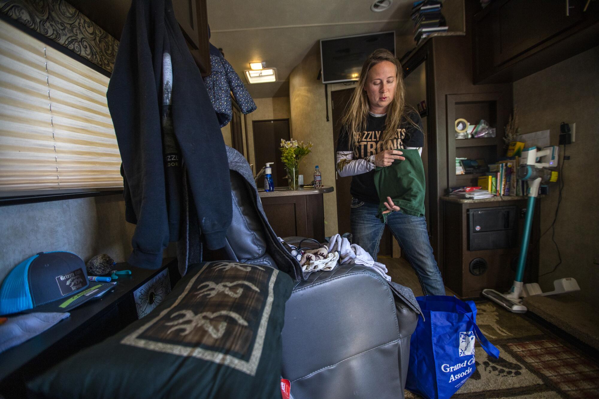 A woman folds laundry in her family's trailer.