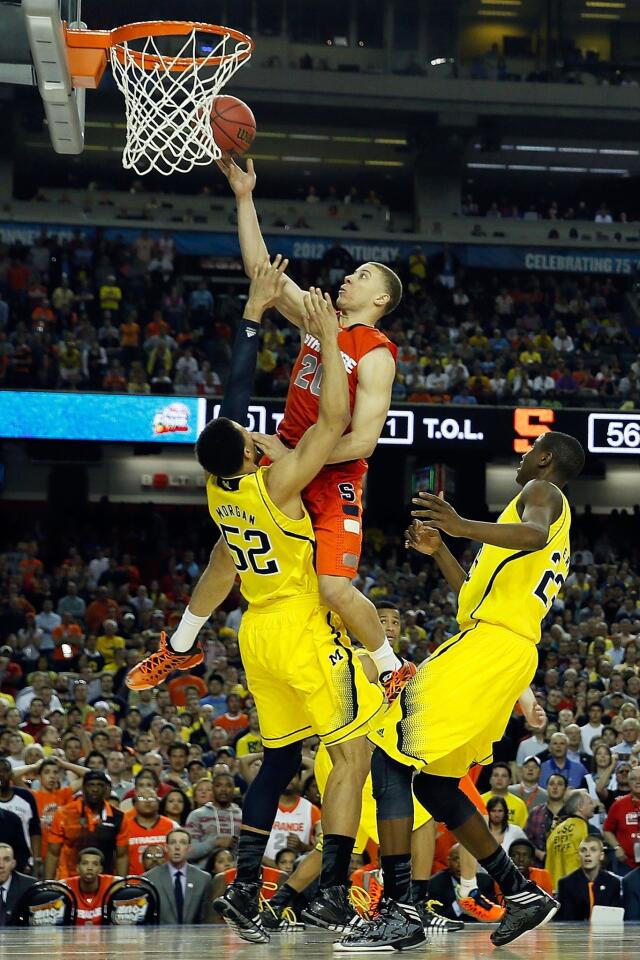 Syracuse guard Brandon Triche collides with Michigan forward Jordan Morgan and gets called for a charging foul on a driving layup in the final minute of the Final Four game on Saturday night.