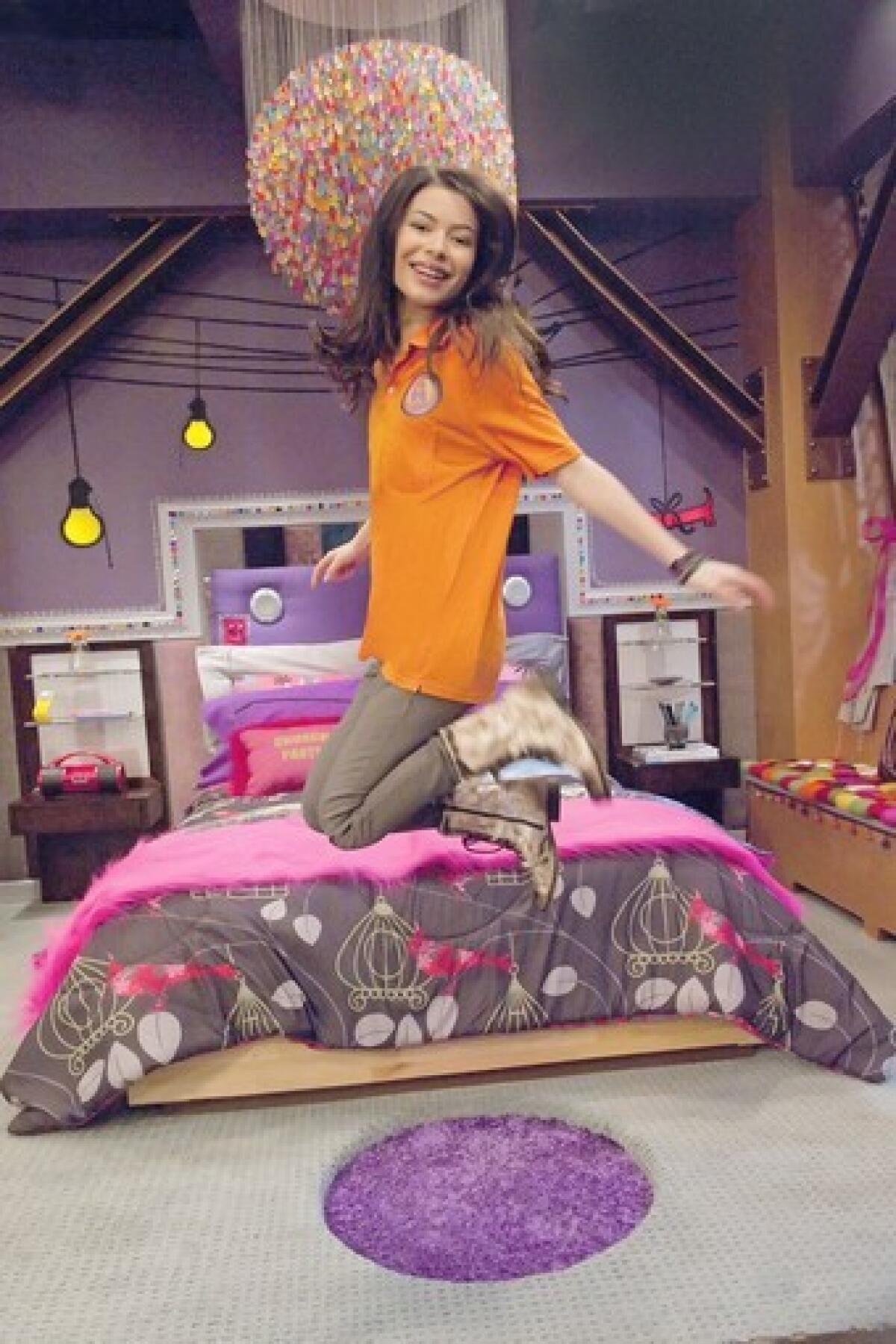 A girl jumps into the air in her brightly colored bedroom