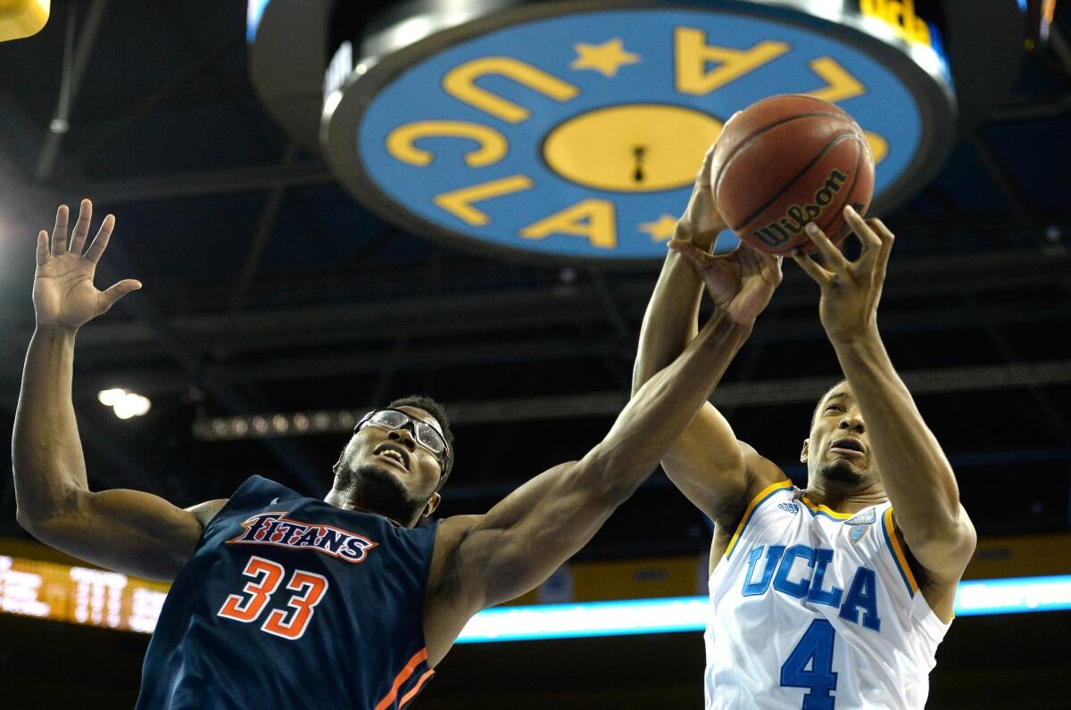 UCLA's Norman Powell grabs a rebound from Cal State Fullerton's Kennedy Esume on Dec. 3.