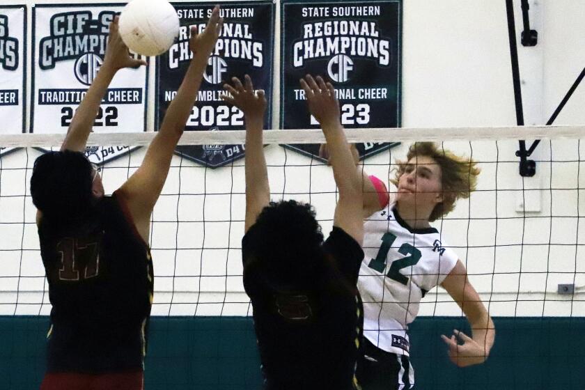 Costa Mesa's Justin Foreman (12) spikes the ball past Estancia's Sebastian Avails (17) and Spencer Lopez (5) during Estancia High School boys' volleyball team against Costa Mesa High School boys' volleyball team in the Battle of the Bell boys' volleyball game at Costa Mesa High School in Costa Mesa on Tuesday, April 3, 2024. (Photo by James Carbone)