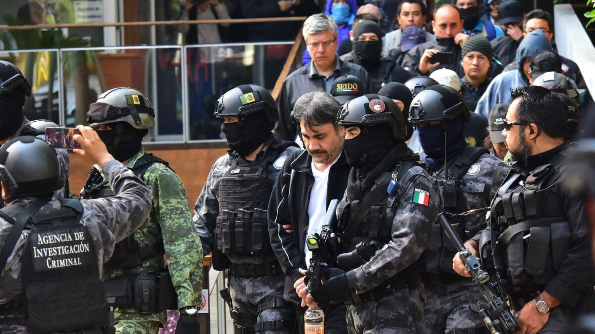Mexican soldiers and agents of the Criminal Investigation Agency escort Damaso Lopez, the senior lieutenant of drug lord Joaquin "El Chapo" Guzman, after arresting him in Mexico City on May 2, 2017. Lopez was extradited to the United States on Friday.
