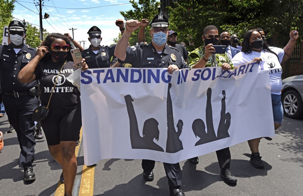Camden County Metro Police Chief Joe Wysocki raises a fist while marching with residents and activists on May 30.