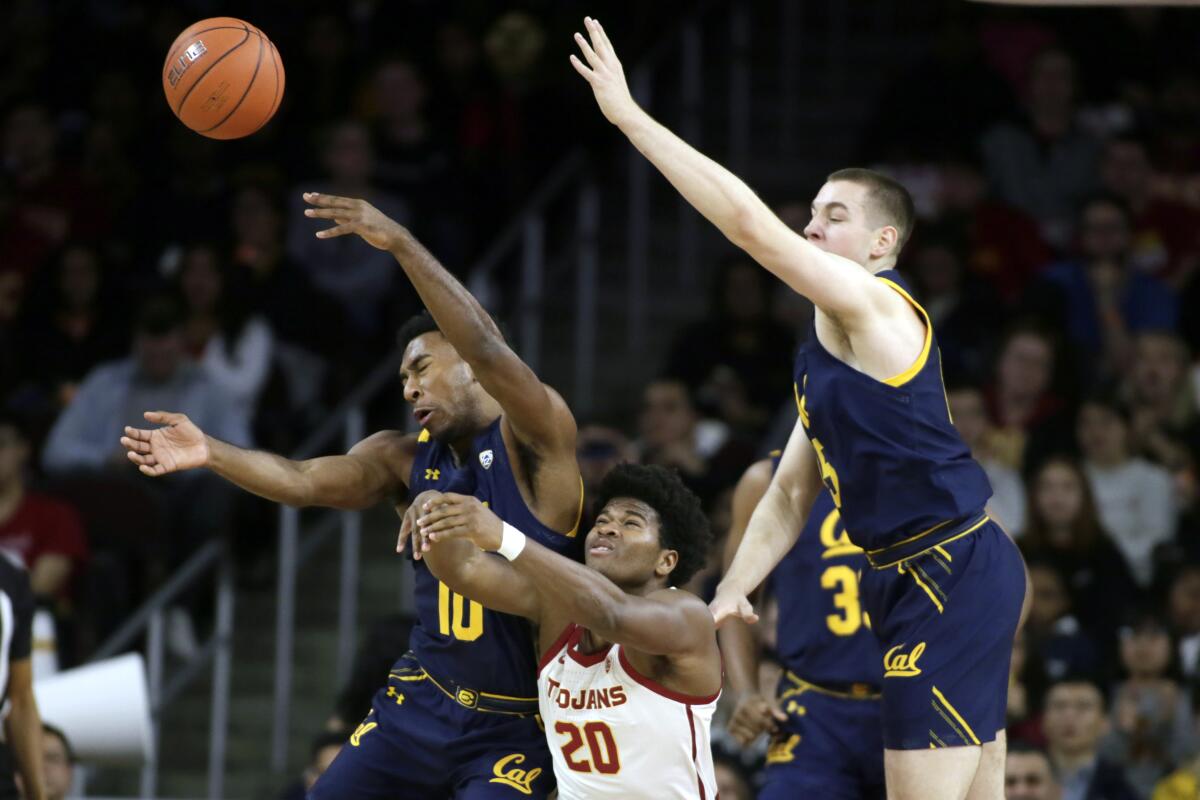 California guard Kareem South, left, battles USC guard Ethan Anderson, center, for the loose ball with forward Grant Anticevich, right, during the first half on Thursday at the Galen Center.