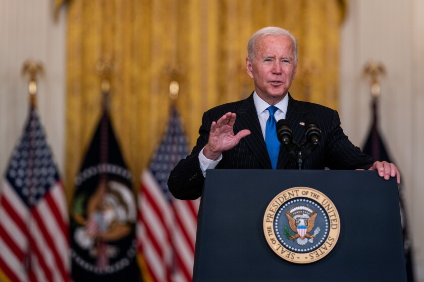 President Biden speaks from behind a lectern 