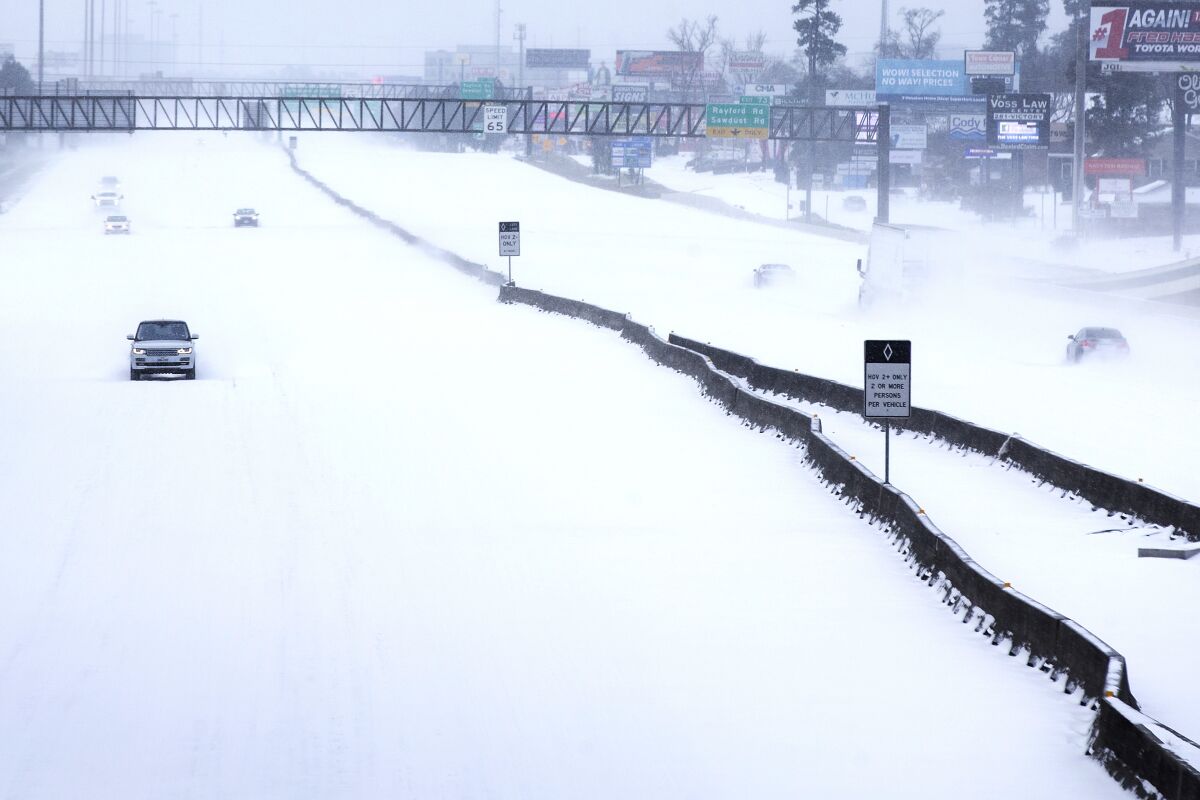 A car is driven on snow-covered Interstate 45 in Woodlands, Texas on Feb. 15.