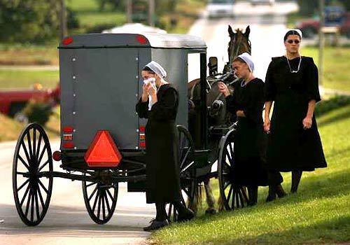 Amish women stand outside a farm in Nickel Mines, Pa., where family and friends gathered before the funeral for children killed in the school shooting.