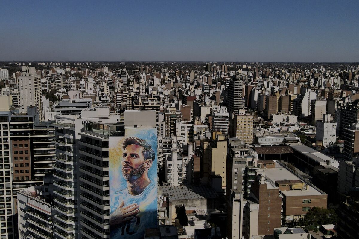 A mural of soccer player Lionel Messi covers the facade of an apartment building.