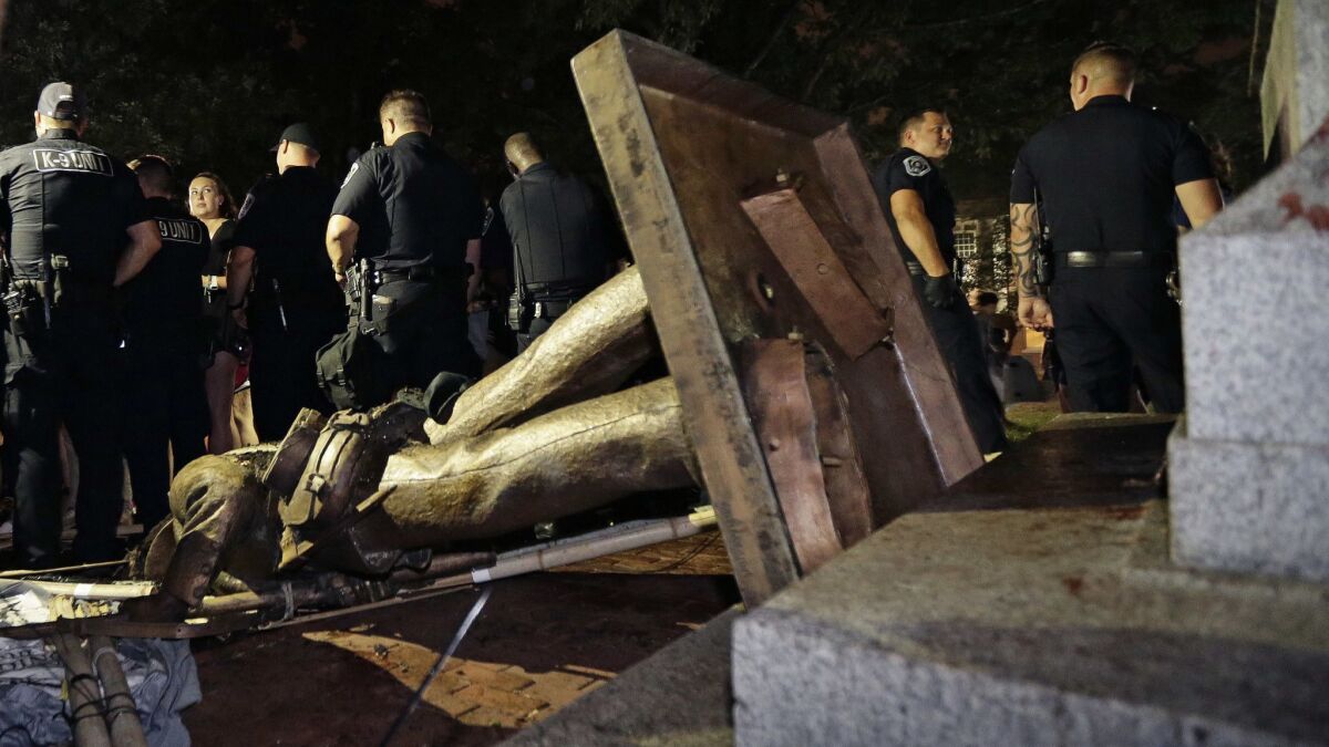 Police stand guard after the Confederate statue known as Silent Sam was toppled by protesters at the University of North Carolina Chapel Hill on Aug. 20, 2018.