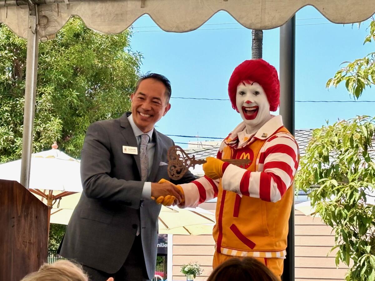 RMHOC executive director Noel Burcelis presents Ronald McDonald with the key to Ronald McDonald House.