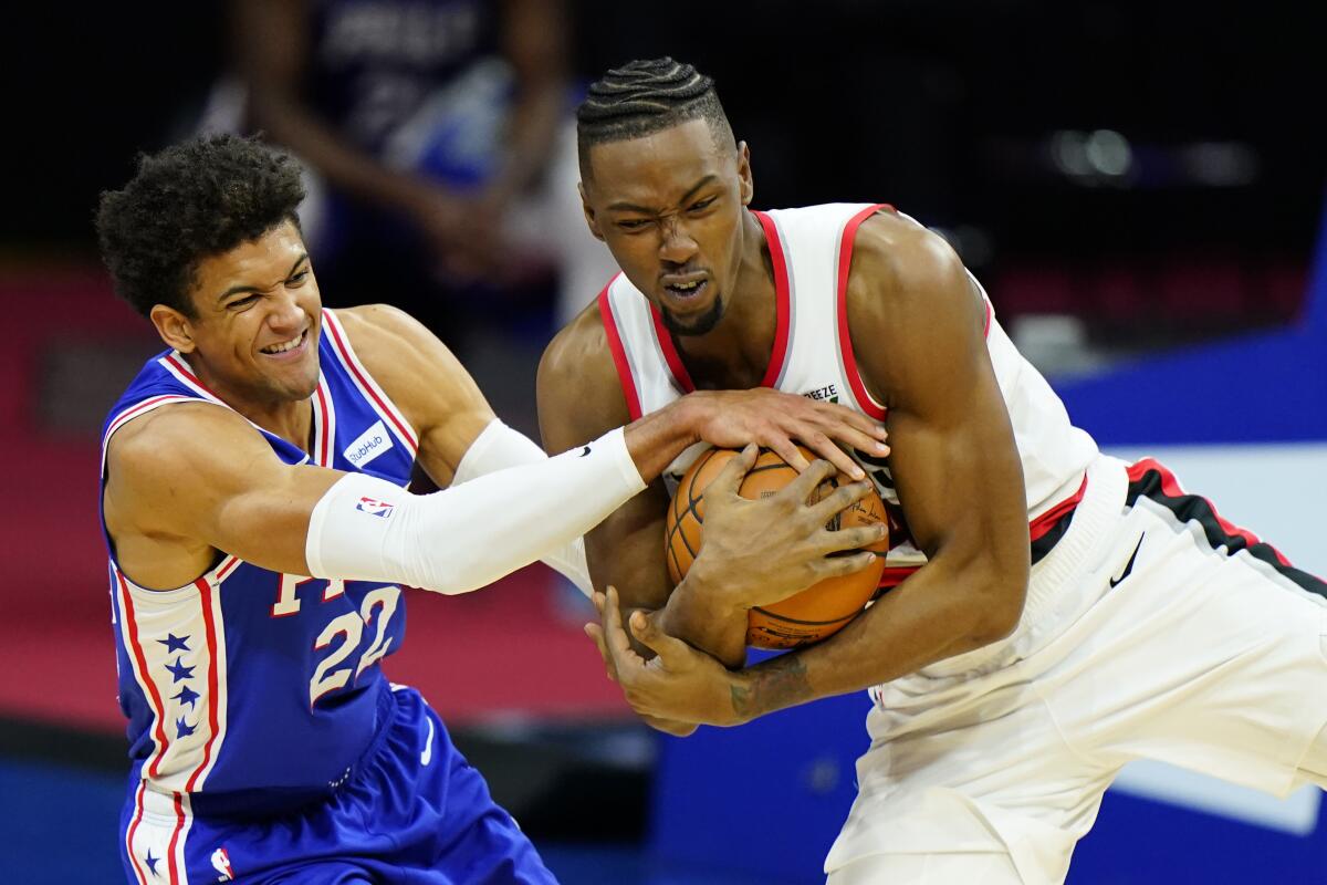 Philadelphia 76ers' Matisse Thybulle and Portland Trail Blazers' Harry Giles III struggle for a loose ball.