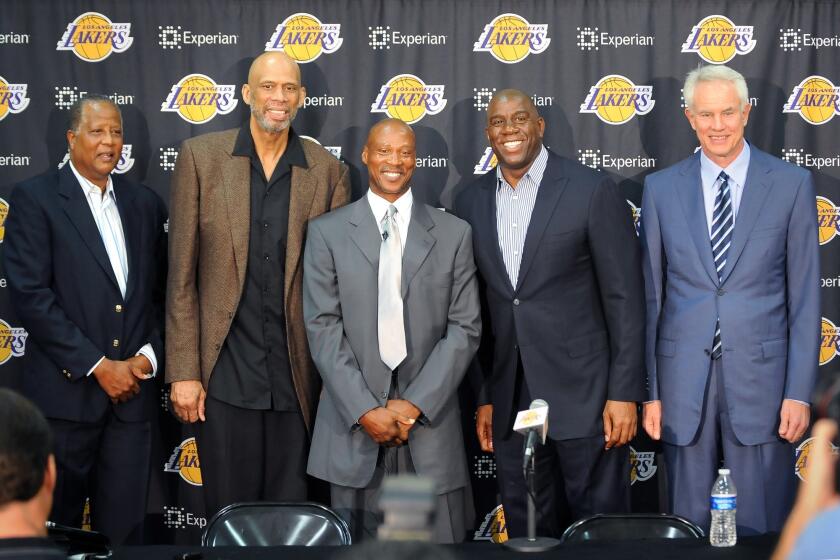 Lakers Coach Byron Scott, center, poses for photos with Lakers greats, left to right, Jamaal Wilkes, Kareem Abdul-Jabbar, Magic Johnson and General Manager Mitch Kupchak during a news conference in El Segundo on July 29.