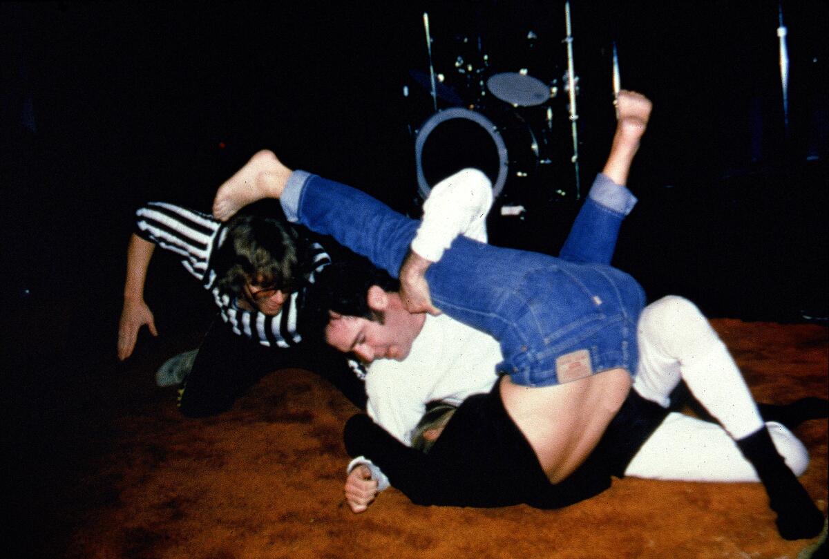 Comedian Andy Kaufman pins Elizabeth Hocker to the mat during a wrestling match 
