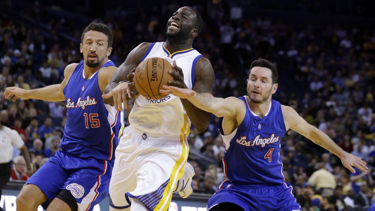 Golden State Warriors small forward Draymond Green, center, drives between Hedo Turkoglu, left, and J.J. Redick of the Clippers during the first half Tuesday.