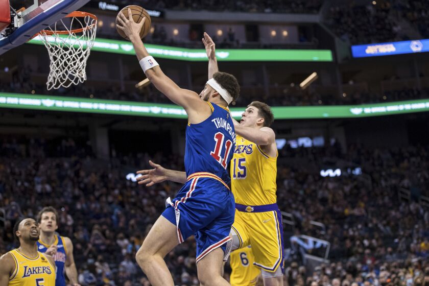 Los Angeles Lakers guard Austin Reaves (15) defends against a shot by Golden State Warriors guard Klay Thompson (11) during the second half of an NBA basketball game in San Francisco, Saturday, Feb. 12, 2022. The Warriors won 117-115. (AP Photo/John Hefti)